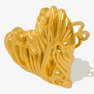 Close-up of golden heart-shaped ring with irregular crinkle texture and metallic shine