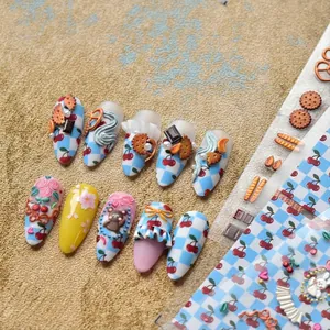 3D embossed nail art stickers with cherry, plaid, and bow designs on gold velvet