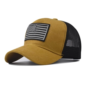 Dettaglio del cappello trucker vintage con corona giallo senape e toppa ricamata USA