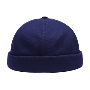 Vue détaillée d'un bonnet docker bleu marine avec bord roulé et bouton sur fond blanc