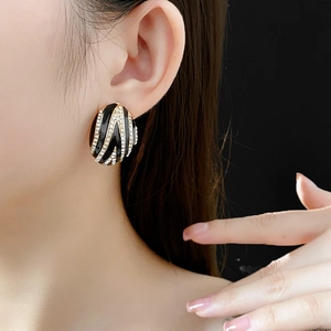 Macro view of vintage gold zebra stripe oval earrings with sparkling diamond accents