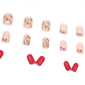 Short square press-on nails with floral patterns and glossy red finish on white background