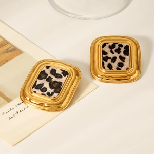 Vue détaillée de boucles d'oreilles carrées en acier doré 18K avec motif léopard incrusté