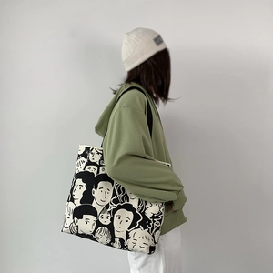 Dettaglio di grande borsa tote in tela con stampa graffiti di volti di cartoni