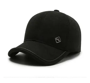 Detail view of high-quality black wool baseball cap with metallic logo and leather edge