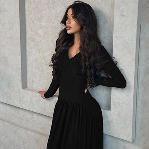 Detail of slim fit black long sleeve V-neck dress showing waist cut and ribbed texture