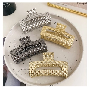Macro view of gold and silver metallic shark hair clips with diamond grid pattern