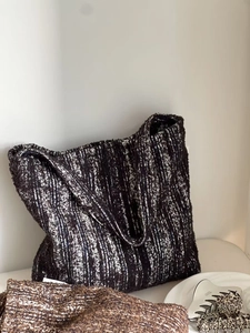 Detailed close-up of a vintage black and white knitted tote bag with wide shoulder strap