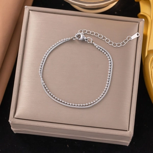 Detail view of double-layer silver titanium steel bracelet with bead and snake chains