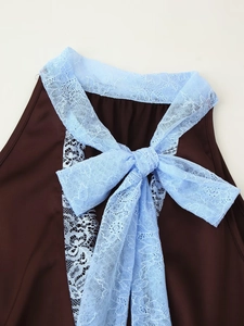 Détail du haut en satin marron foncé avec un nœud en dentelle bleu clair au décolleté