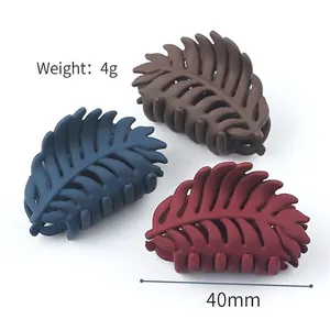 Three matte leaf-shaped hair claws in navy blue, brown, and dark red colors