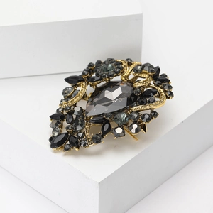 Detailed macro view of vintage gold alloy brooch with black rhinestones and crystals