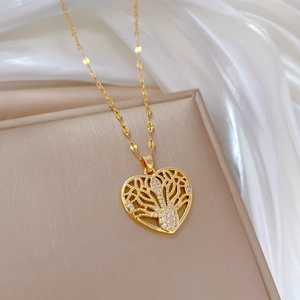 Gold hollow heart tree of life pendant necklace with crystals on beige box