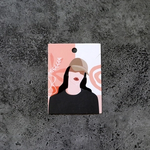 Detail view of a creative printed jewelry display card with girl illustration on grey background