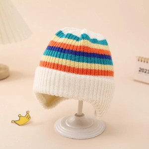 Detail of rainbow striped knit baby hat with earflaps on white display stand