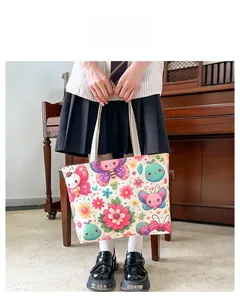 Detail of canvas tote bag with colorful cartoon prints held by a model in a school style