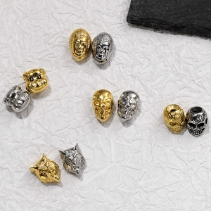 Macro view of Buddha, wolf and skull stainless steel beads in gold and silver finishes