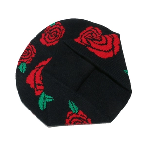 Close-up of red rose floral jacquard pattern on a black knit beanie hat