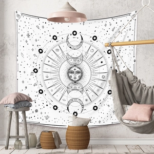 Bohemian black and white sun and moon mandala tapestry hanging in a cozy bedroom