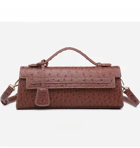 Detailed front view of brown ostrich texture baguette bag with golden hardware and handle