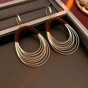 Chic multi-layered oval gold hoop earrings with dark brown thread wrap in jewelry box