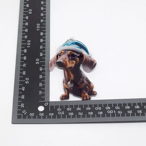 Detailed size measurement of acrylic dachshund pendant with a festive blue Christmas hat