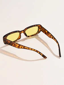 Detail of retro rectangular sunglasses with leopard print frame and yellow lenses