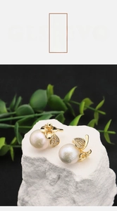 Detail of floral gold earrings with freshwater pearls and micro-pave leaf accents