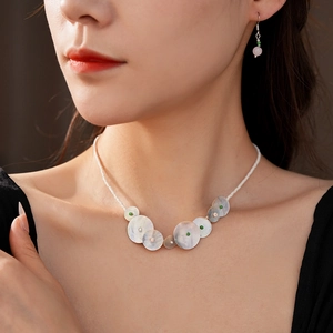 Detail of beaded necklace with shell charms and matching pink crystal earrings set