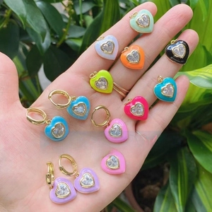 Colorful enamel heart pendants with clear zircons held in hand for size display
