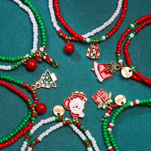 Christmas beaded bracelets with Santa and tree charms on dark green background