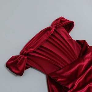 Gros plan sur le tissu en velours rouge foncé montrant une texture lisse et brillante