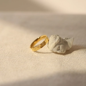 Macro view of gold plated dragon scale ring with unique hammered texture and icy finish