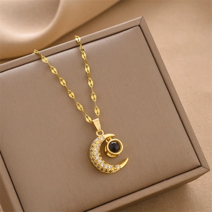 Gold moon projection necklace with micro-pave crystals on a brown jewelry box