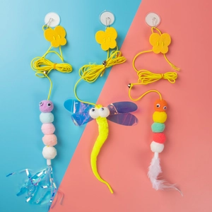 Hanging cat toy set with colorful feathers and plush balls on pastel split background