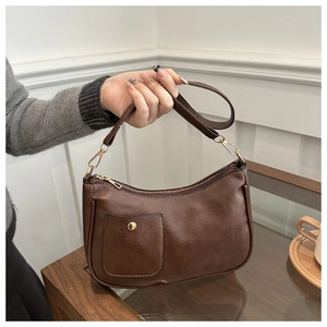 Detailed macro view of dark brown PU leather shoulder bag featuring gold hardware buckles
