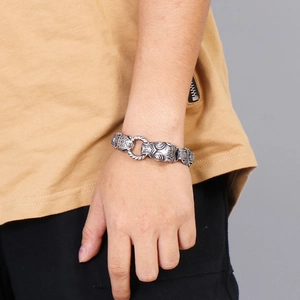 Detailed view of silver lion head bracelet in vintage titanium steel worn on wrist