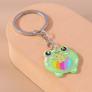 Macro detail of cute acrylic green frog keychain holding a rainbow heart cookie