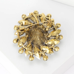 Back view of vintage gold leaf brooch showing pin fastener and detailed metal texture