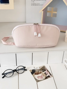 Pink large-capacity cosmetic bag with dual zippers and handle in a home setting