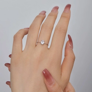 Detailed view of silver adjustable chain ring with oval clear zircon stone on a hand