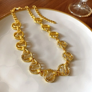 Macro detail of golden snake-pattern necklace with sparkling red and clear rhinestones