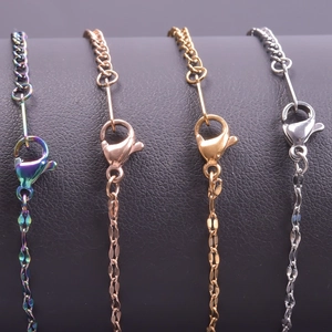 Close-up of multicolored, rose gold, and silver stainless steel curb chains with lobster clasps
