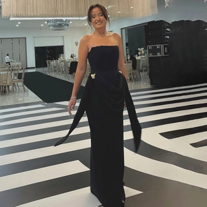 Détail d'une élégante robe de soirée bustier noire avec boucles dorées à la taille