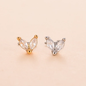 Macro detail of gold and silver L-shaped nose studs with marquise-cut cubic zirconia