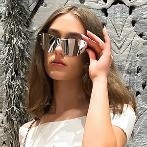 Cyberpunk frameless silver mirror cat eye sunglasses worn by model in profile view