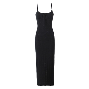 Détail de la robe moulante noire en maille montrant le motif ajouré et le laçage chic