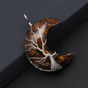 Macro detail of crescent moon pendant with Tiger Eye stones and Tree of Life wire wrap