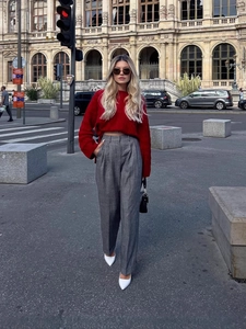 Chic red oversized knit sweater paired with grey wide-leg trousers in a street setting