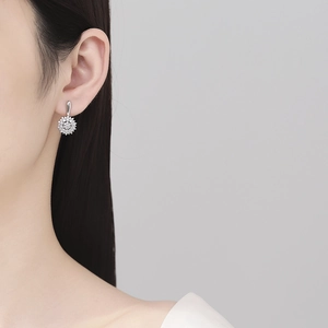 Elegant silver sunflower earrings with sparkling zircon stones worn by a female model
